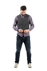 Bearded fashionable young man buttoning vest