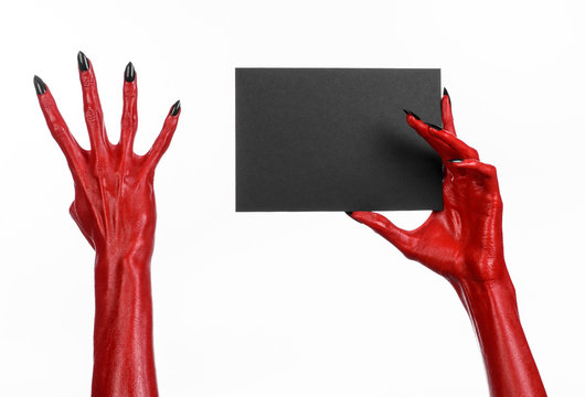 Red devil hand with black nails holding a blank black card