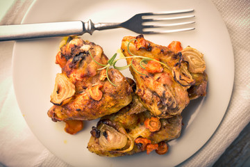 Vintage photo of oven-baked chicken wings with vegetables