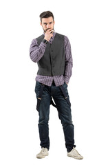 Naklejka premium Young serious hipster smoking isolated