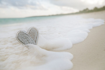Obraz premium wooden heart in sea waves, live action ...