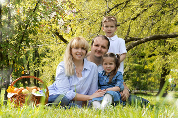 Naklejka na ściany i meble Beautiful family with kids having picnic outdoors