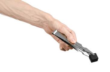 man holding a forceps with coal and puts them into a clay bowl