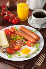 english breakfast with fried egg sausages bacon tomatoes beans