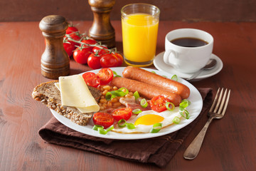 english breakfast with fried egg sausages bacon tomatoes beans