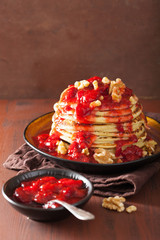 stack of pancakes with strawberry jam and walnuts. tasty dessert