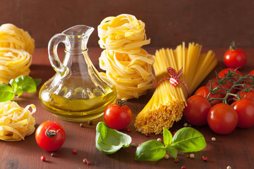 raw pasta olive oil tomatoes. italian cooking in rustic kitchen