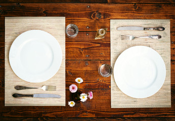 Table setting for two with empty plates - rustic wooden table - Powered by Adobe