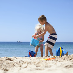 Children playing with sand on beach