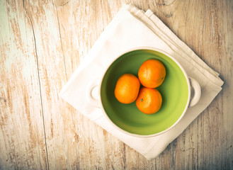 Vintage photo of tangerines in a bowl on a wood