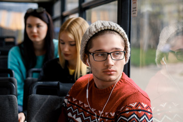 man rides a bus, listening to music