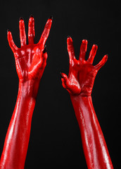 Red Devil's hands, red hands of Satan, black background isolated