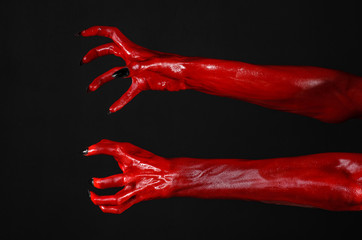 Red Devil's hands, red hands of Satan, black background isolated