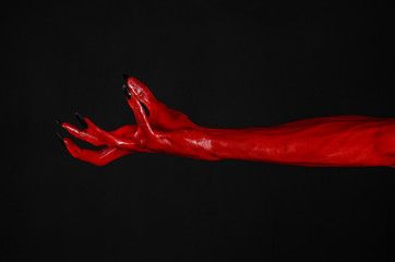 Obraz na płótnie Canvas Red Devil's hands, red hands of Satan, black background isolated