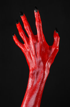 Red Devil's hands, red hands of Satan, black background isolated