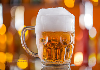 Bottle of beer with glass on bar desk