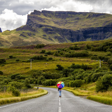 UK, Scotland, Woman with umbrella on country road