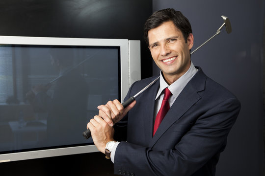 Businessman with golf club in the office