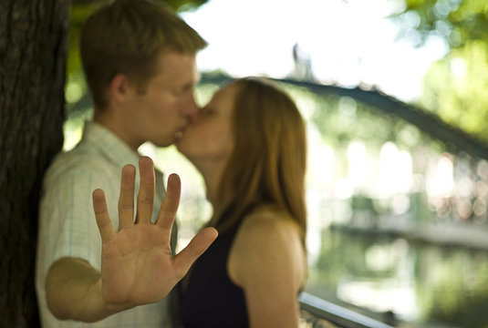 Man kissing a woman and holding his hand out, Canal St Martin, Paris, France
