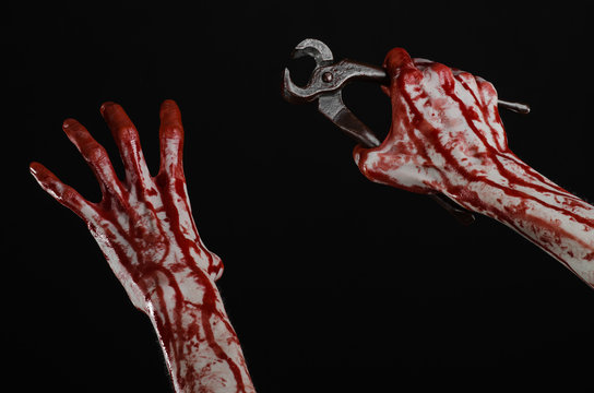 bloody hand holding a pliers on a black background