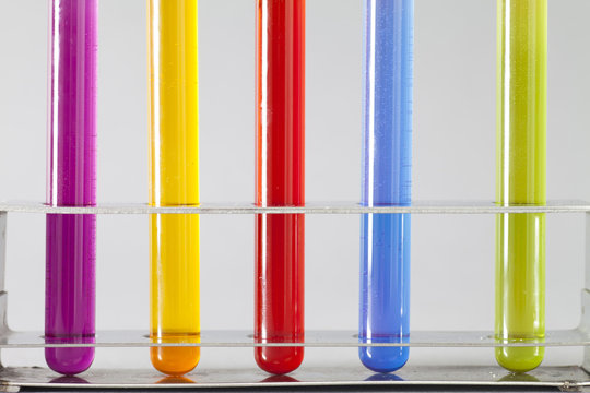 Close-up of a row of five Test tubes with coloured liquid in a test tube rack 