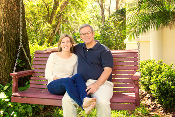 Mature couple sitting on wooden swing