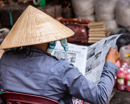 Rear view of man reading newspaper