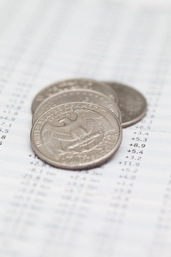 Close-up of a stack of American quarters on a document with financial figures