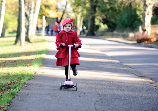 Little girl (4-5) riding push scooter