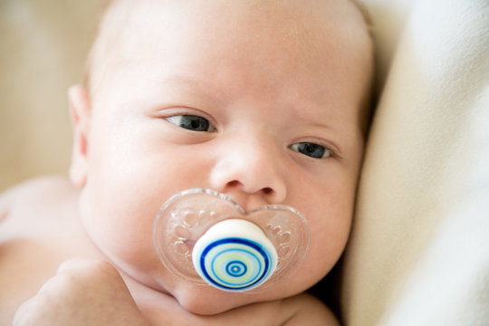 Close-up portrait of a baby boy with a dummy