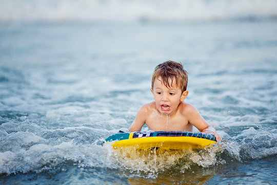 Little boy (2-3) on surfboard