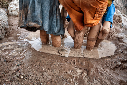 USA, Colorado, Children (6-7) playing in mud
