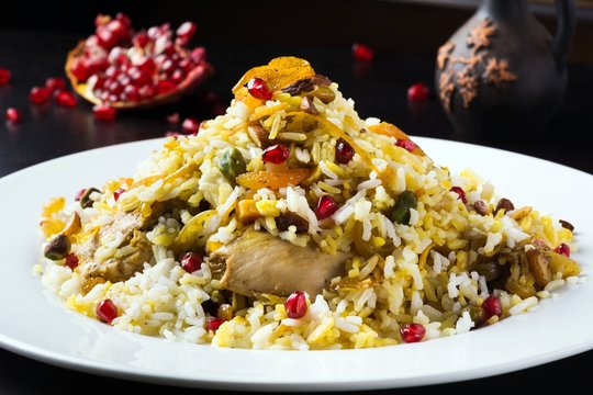Festive middle eastern Persian jeweled rice dish (javaher polow) with chicken, orange peel, rose water, pistachios, apricots, almonds and pomegranate seeds 