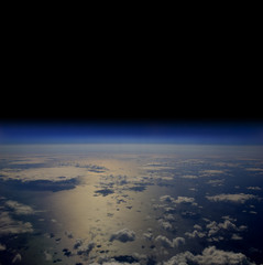 The Earth in space with clouds over the open sea.