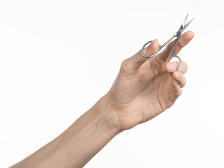 Hand holding scissors for manicure isolated on white background