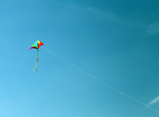 kite flies high in the sky blue