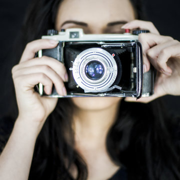 Young woman with old camera