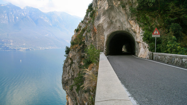 Fototapeta Straight road into an alpine tunnel by Lake Garda (Benaco), Italy