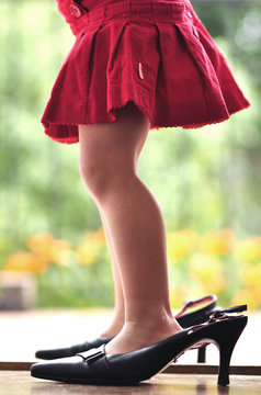Close-up of a Girl trying on her mother's high heel shoes