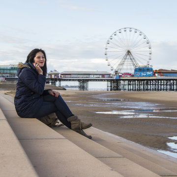 UK, England, Blackpool, Woman with phone on steps
