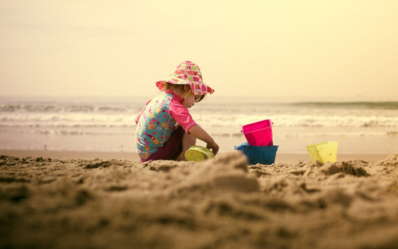 Girl (18-23 months) playing in sand on beach 