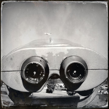 Close-up of coin operated binoculars looking towards airplane