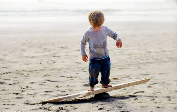 Boy ( 2-3 ) balancing on wooden plank