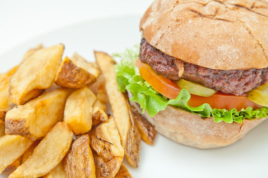 Close-Up of a Hamburger And thick cut chips on a plate