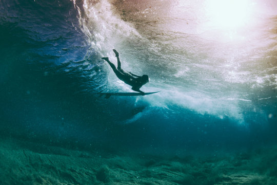 Female surfer duck diving under a wave in Pacific Ocean, Hawaii, America, USA