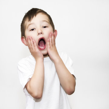 Portrait of a young boy with his hands on his face screaming