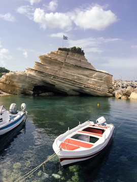 Greece, Zakynthos, Rocky coast and boats moored in foreground