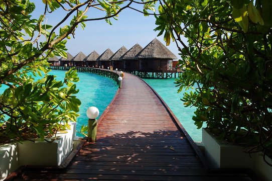 Maldives, View along elevated footbridge leading across water to row of stilt huts