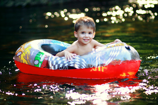 Little boy (2-3) in inflatable kids boat
