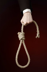Hand of a businessman holding a loop of rope for hanging